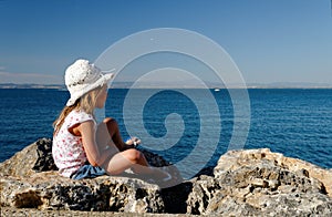 Girl on seaside rocks