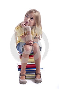 Girl seated on a stack of books