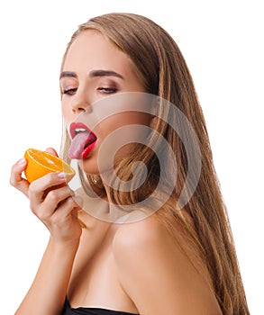 The girl seductively licks an orange on a white isolated background