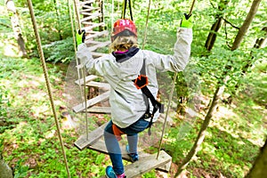 Girl seen from above climbing in high rope course