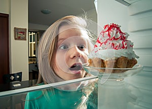 Girl sees the sweet cake the fridge