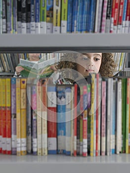 Girl Selecting Books From Library Bookshelf