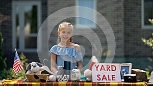 Girl selling old toys on yard sale, earning pocket money, young business lady