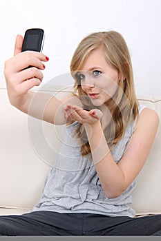 Girl sends a kiss to her cellphone