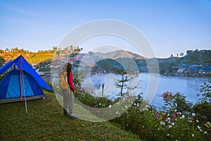 The girl set up a camp on the mountain near the lake, Camping Travel Concept, natural rhythms, fog in the winter