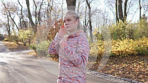 A girl sets the music before a morning run in the park.