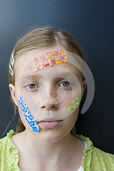 Girl with several colorful bandages