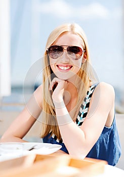 Girl in shades in cafe on the beach