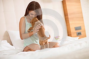 Girl share tenderness with her lapdog in bed