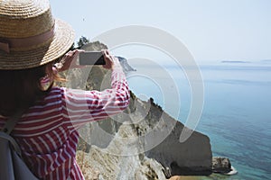 Girl  and sheer white cliffs of Cape Drastis near Peroulades