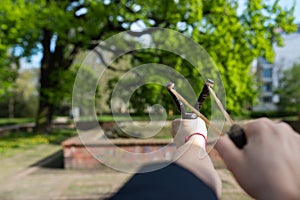 Girl shooting from the professional wooden slingshot