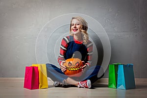 Girl with shopping bags and Halloween pumpkin