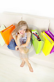 Girl with shopping bags on sofa