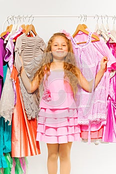 Girl during shopping standing between hangers