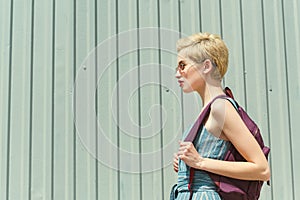 girl with short hair posing with backpack