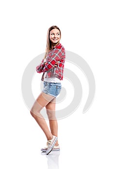 Girl in shorts and checked shirt, arms crossed, isolated