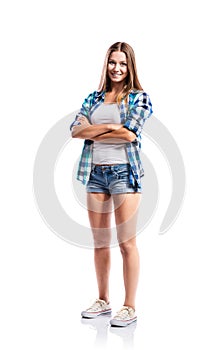 Girl in shorts and checked shirt, arms crossed, isolated