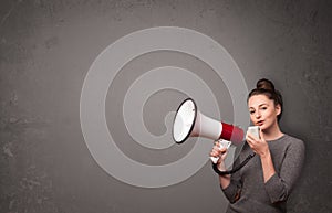 Girl shouting into megaphone on copy space background