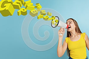 Girl shouting with megaphone, loudspeaker on studio background. Sales, offer, business, cheering fun concept.