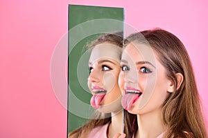 Girl show tongue at mirror as multifaceted personality. Beauty and fashion. Hairdresser salon and makeup concept photo