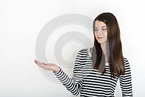 Girl showing empty copy space on open hand palm for text or product, white background. Smiling girl presenting point. Proposing pr