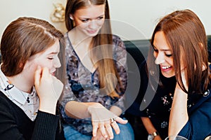 Girl showing engagement ring to friends