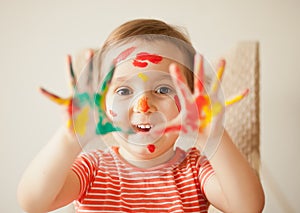 Girl showing painted hands. Hands painted in colorful paints. Education, school, art and painitng concept