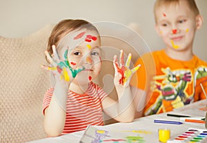 Girl showing painted hands. Hands painted in colorful paints. Education, school, art and painitng concept