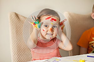 Girl showing painted hands. Hands painted in colorful paints. Education, school, art and painitng concept