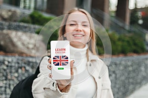 Girl showing smart phone with online learn English concept on screen