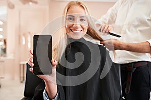 Girl showing smartphone display to the camera