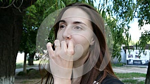 A girl shows a cookie and eats it in slow motion.