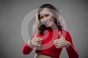 Girl shows gestures with thumb up. It`s cool and great.