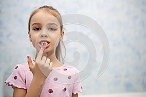 The girl shows her mouth without one milk tooth that has fallen out