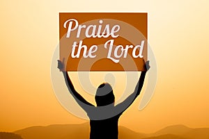 Girl with a sign with word praise the lord photo