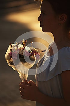 Girl silhouette with bouquet of flowers