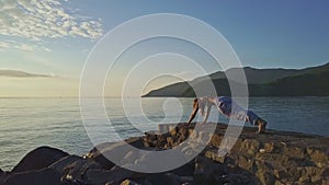 Girl Silhouette Holds Yoga Pose against Sunrise above Ocean