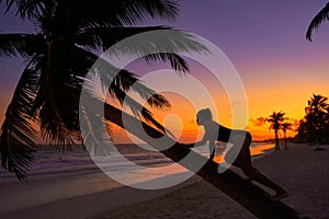 Girl silhouette palm tree Caribbean sunset