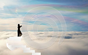 Girl Silhouette on stairs above the clouds rainbow sky straiway to heaven