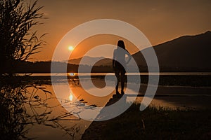 Girl silhouette standing over the lake annone brianza photo