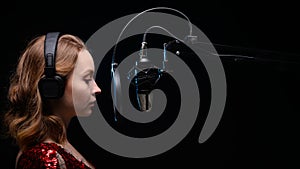 Girl singer sings into a microphone, with a spectacular background, vocals, recording studio, recording a track. On a black photo