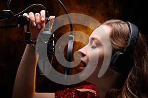 Girl singer sings into a microphone, with a spectacular background, vocals, recording studio, recording a track photo