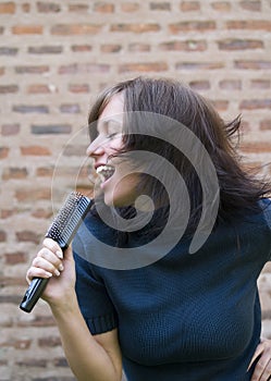 Girl singing on her hair brush