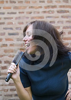 Girl singing on her hair brush photo