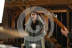 Girl singing into a microphone to record vocals