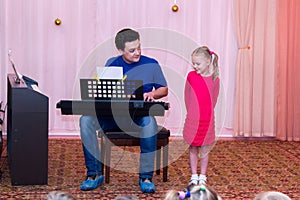 Girl sings while her father plays synthesizer