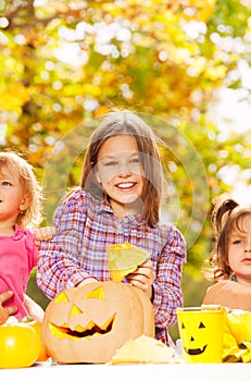 Girl with sisters carve pumpkins for Halloween photo