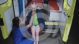 Girl sit an ambulance car with oxygen mask.