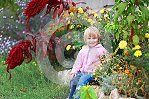 Girl sit in flowers in the park.