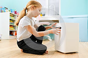 Girl sit with humidifier at home interior